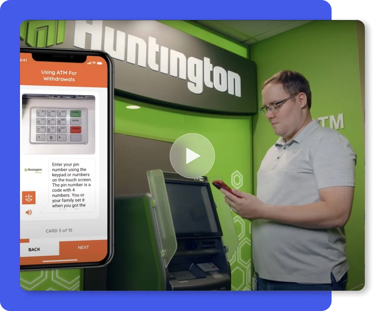 A man using a Huntington ATM, with the MagnusCards Card Deck for using an ATM on a phone beside him.