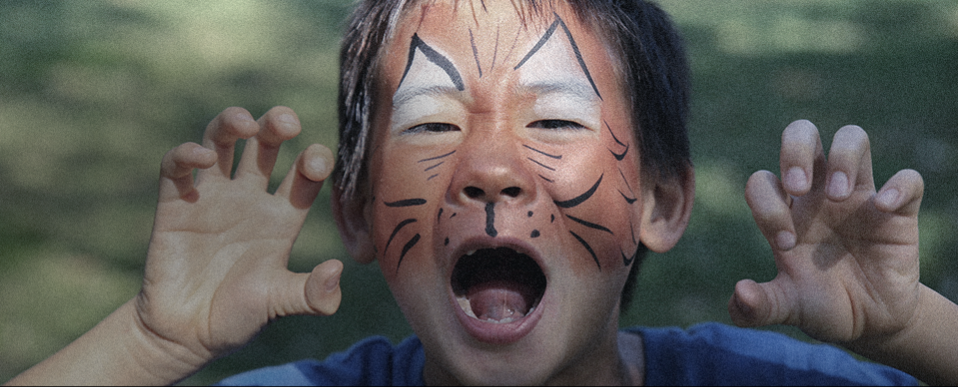 Kid with tiger face paint roaring