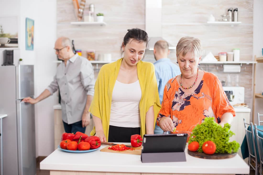 Woman happily cooks with her mother.