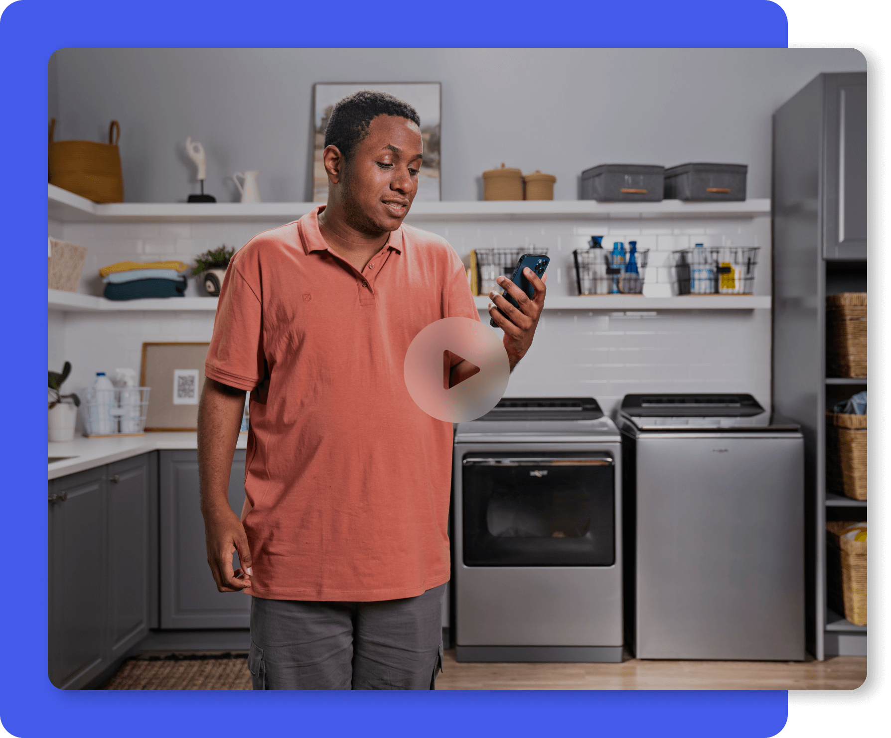 Young man looking at his phone in a laundry room setting. He is learning to do laundry using the MagnusCards app.