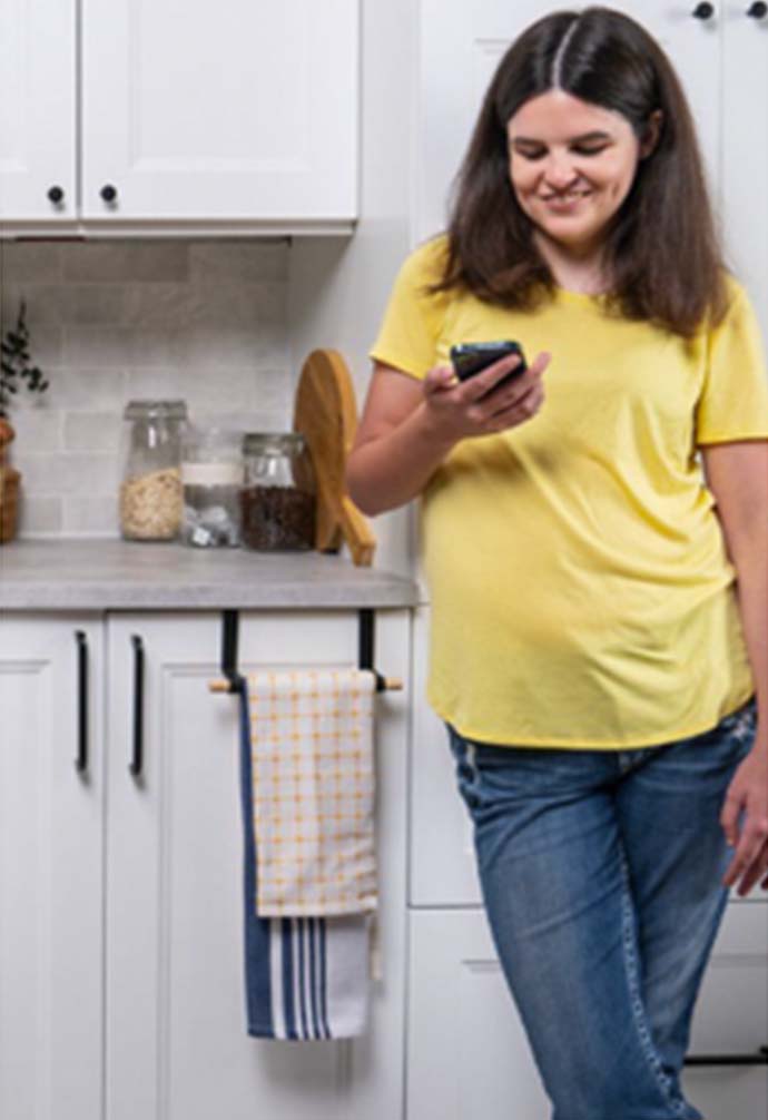 Woman looking at phone in kitchen